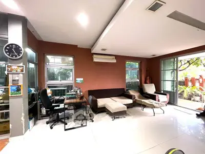 Spacious living room with modern furniture and large windows offering garden views.