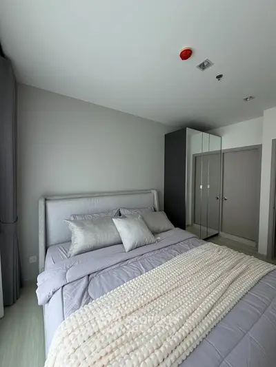 Modern bedroom with stylish decor and cozy bedding in a contemporary apartment.