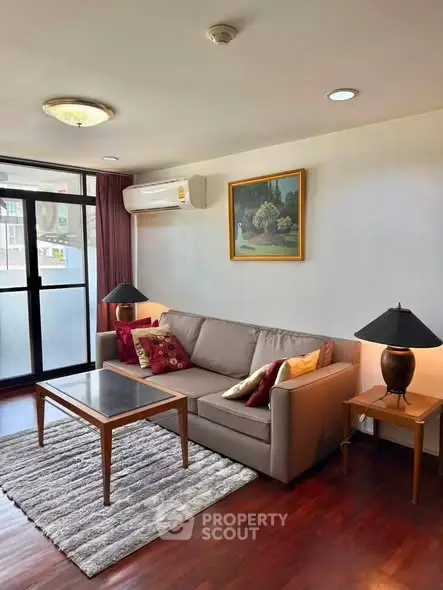 Charming living room with cozy sofa, elegant decor, and natural light from large window.