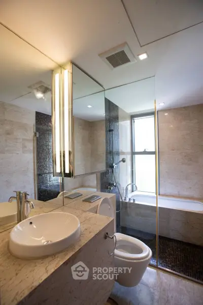 Luxurious modern bathroom with elegant fixtures and natural stone finishes.