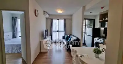 Modern apartment interior with cozy living room and kitchen area, featuring stylish decor.