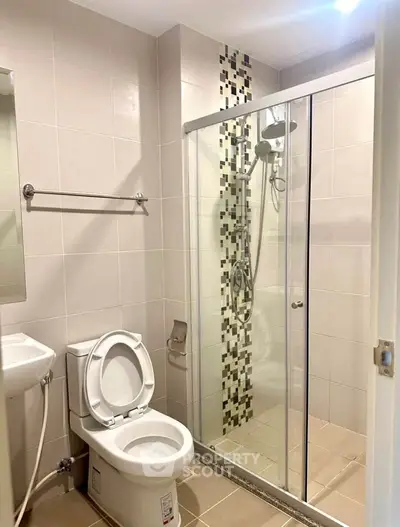 Modern bathroom with glass shower enclosure and stylish tile accents.