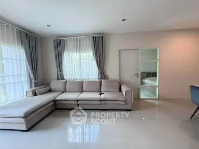 Spacious living room with modern sectional sofa and large windows for natural light.