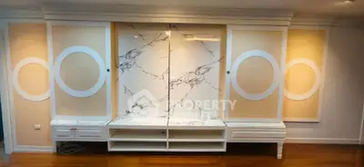 Elegant living room with marble accent wall and custom cabinetry