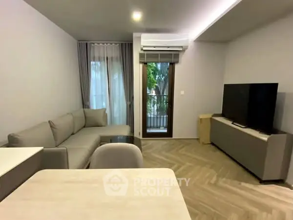 Modern living room with sleek furniture and large TV, featuring a cozy atmosphere.