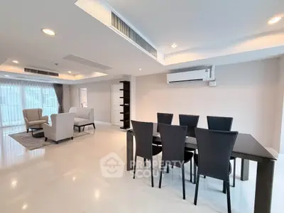 Spacious modern living and dining area with elegant furniture and ample natural light.
