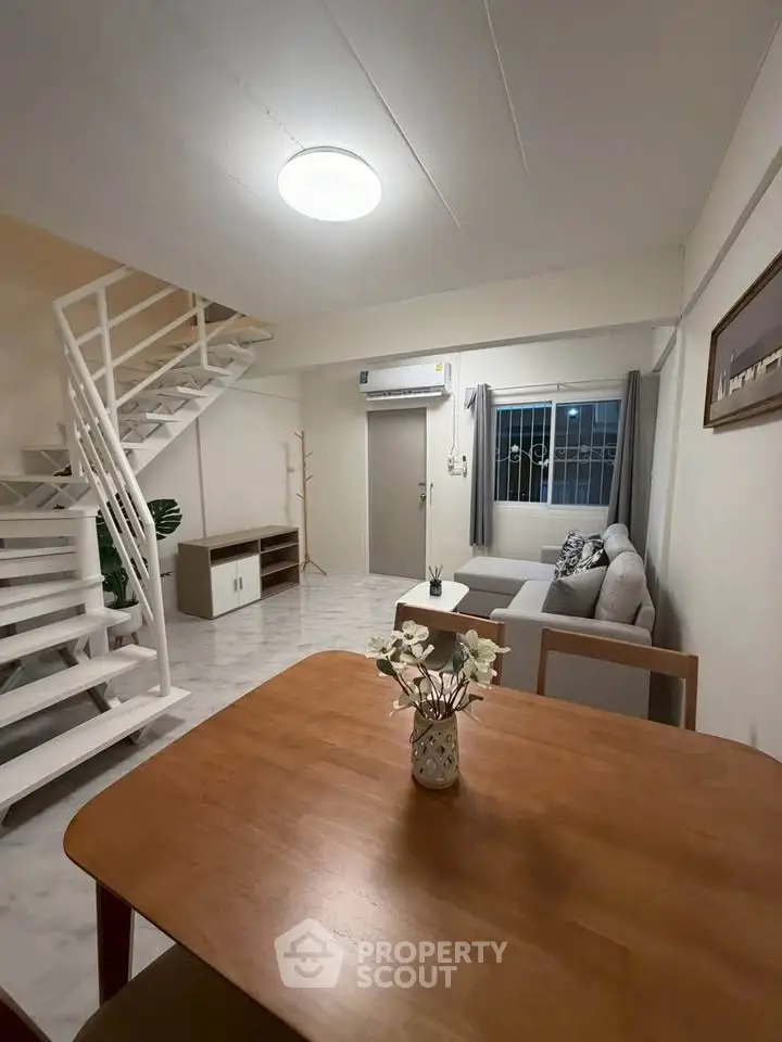 Spacious living room with modern staircase and cozy seating area, perfect for family gatherings.