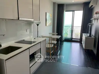 Modern open-layout kitchen and living area with balcony view in stylish apartment.