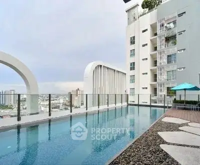 Luxurious rooftop pool with stunning city views in modern high-rise building.