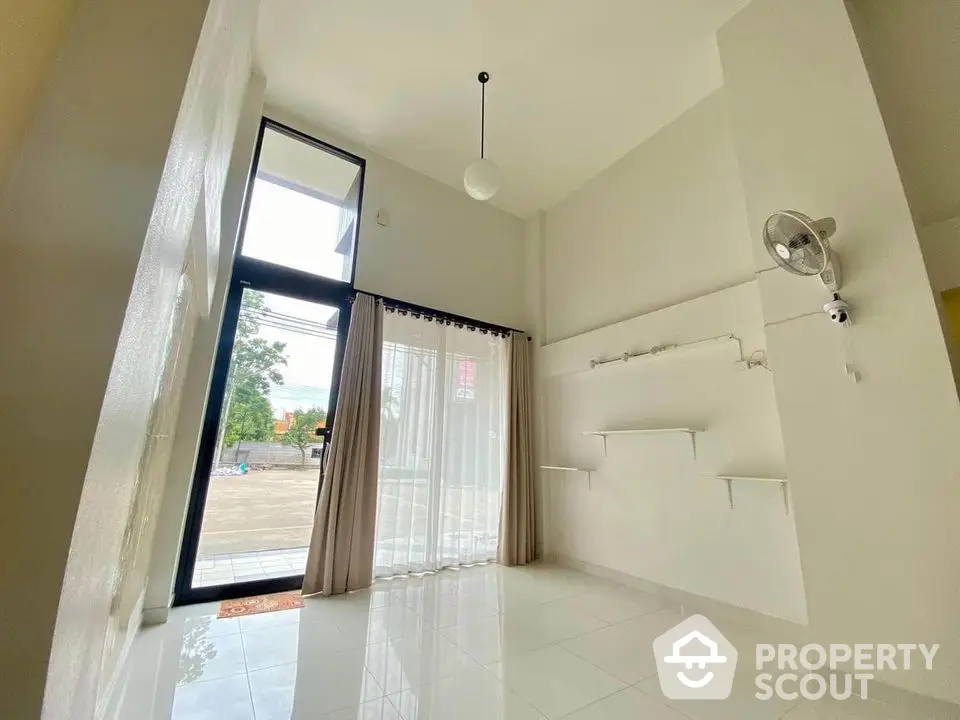 Spacious modern interior with high ceilings and large windows, perfect for natural light.