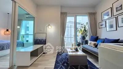 Modern living room with stylish decor and natural light, featuring a cozy seating area and elegant artwork.