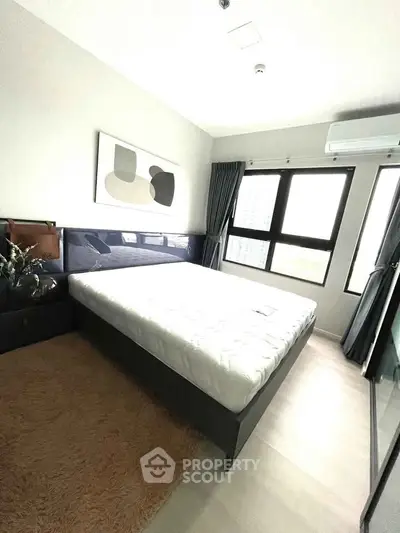 Modern bedroom with large windows and stylish decor in a high-rise apartment.