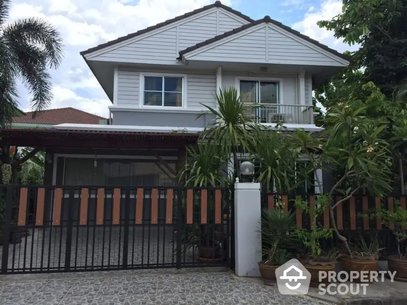 Charming two-story house with lush garden and spacious driveway in a serene neighborhood.