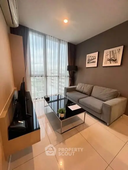 Modern living room with sleek furniture and large windows offering a stunning view.