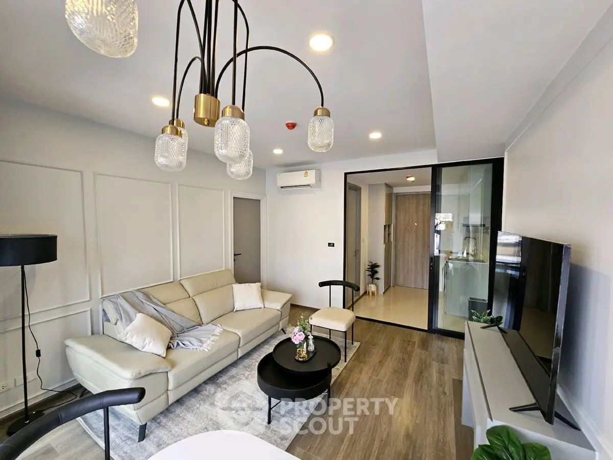 Modern living room with elegant lighting and cozy seating area in a stylish apartment.