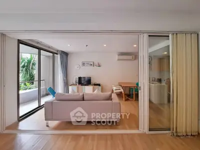 Spacious living room with modern decor and balcony view, perfect for relaxation and entertainment.