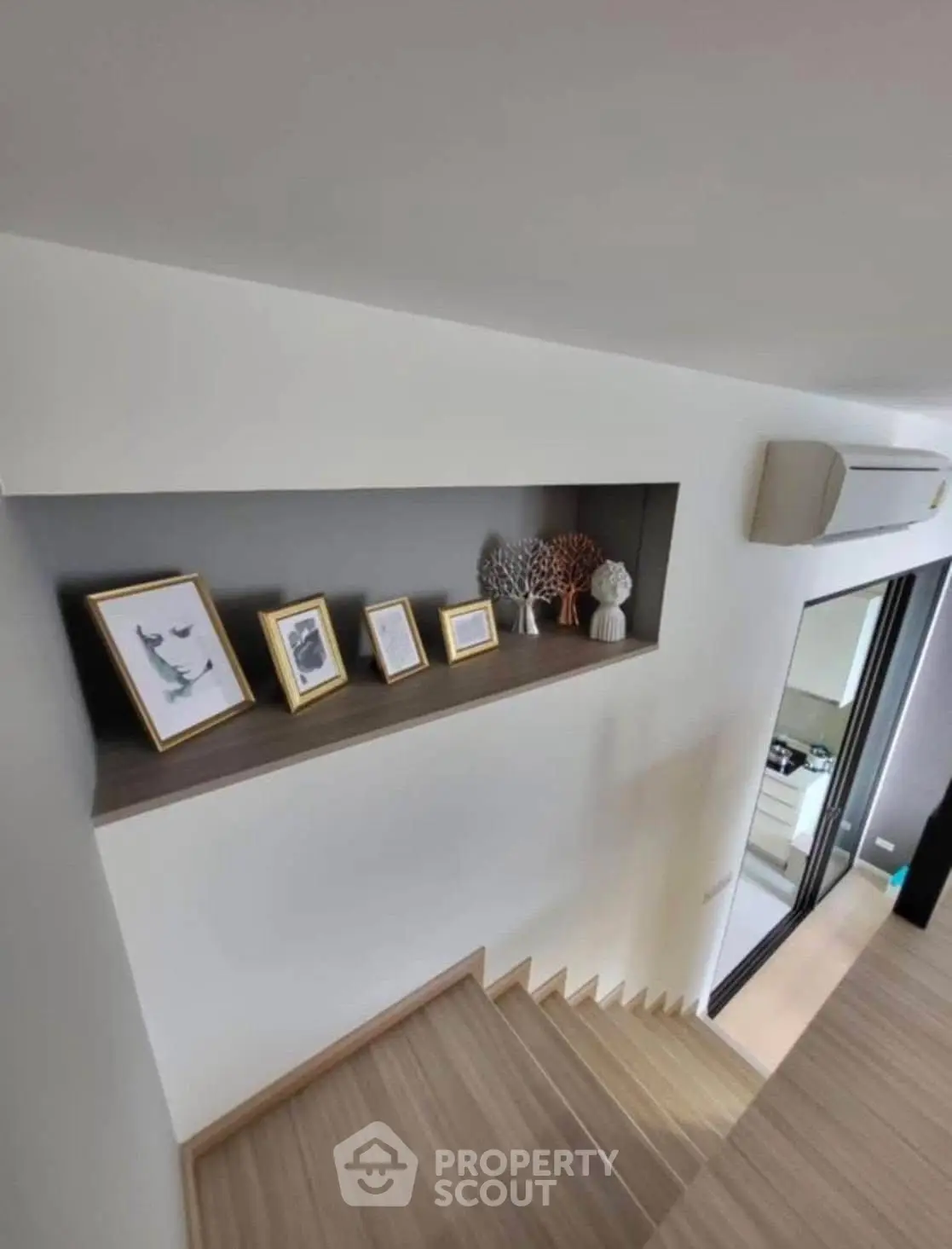 Modern staircase with decorative shelf and framed art in stylish home interior