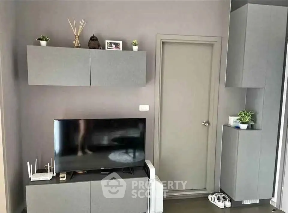 Modern living room with sleek grey cabinets and flat-screen TV