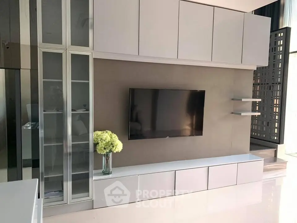 Modern living room with sleek cabinetry and mounted TV, perfect for stylish urban living.