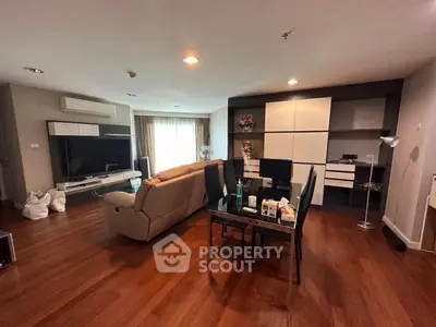 Spacious living room with modern furniture and wooden flooring, perfect for relaxation and entertainment.