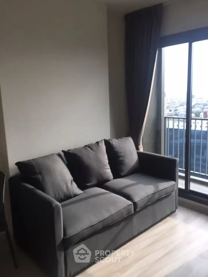 Modern living room with cozy gray sofa and city view balcony, perfect for urban living.