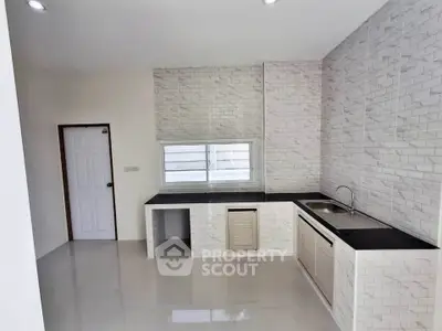 Modern minimalist kitchen with sleek countertops and ample natural light.