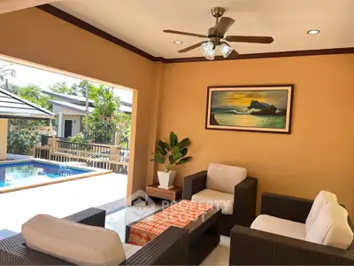 Luxurious living room with pool view, stylish furniture, and elegant decor in a tropical setting.