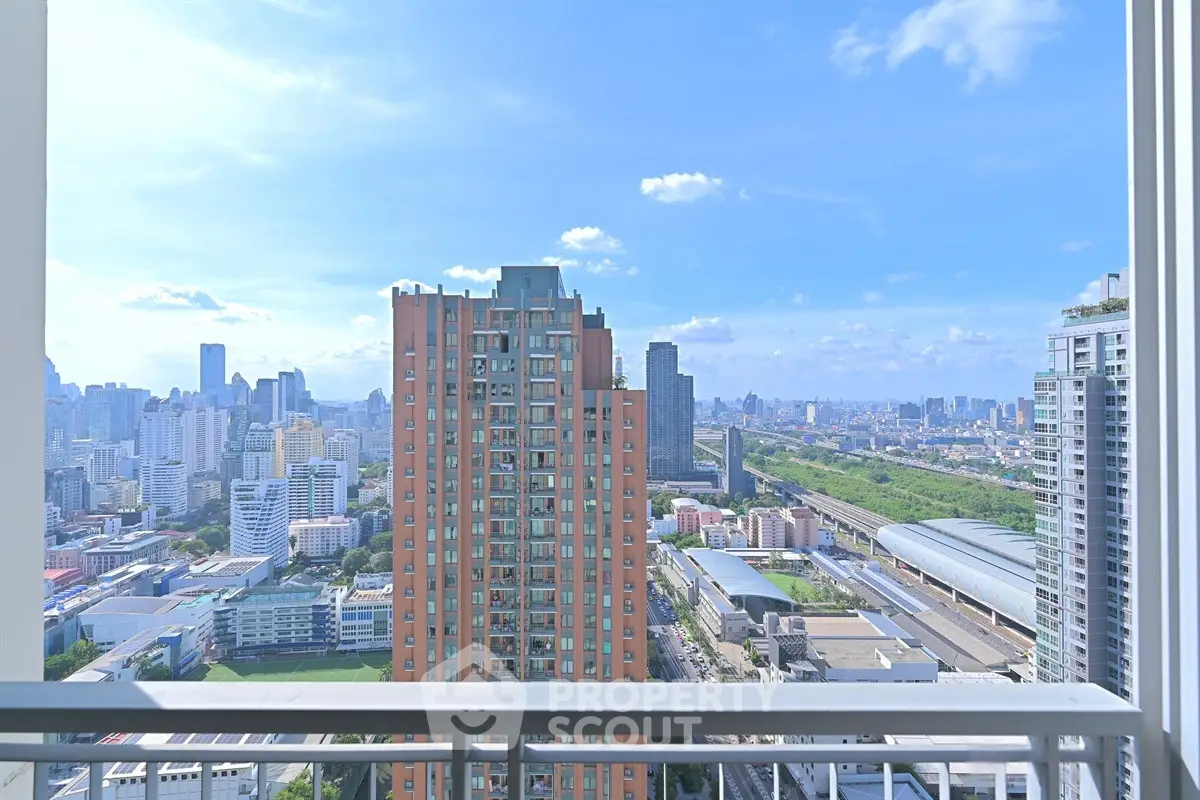 Stunning cityscape view from high-rise balcony with clear blue sky