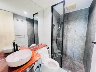 Modern bathroom with sleek design, featuring a glass shower and stylish basin.