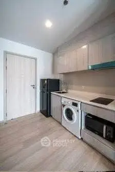 Modern kitchen with sleek appliances and wooden cabinetry in a compact layout.
