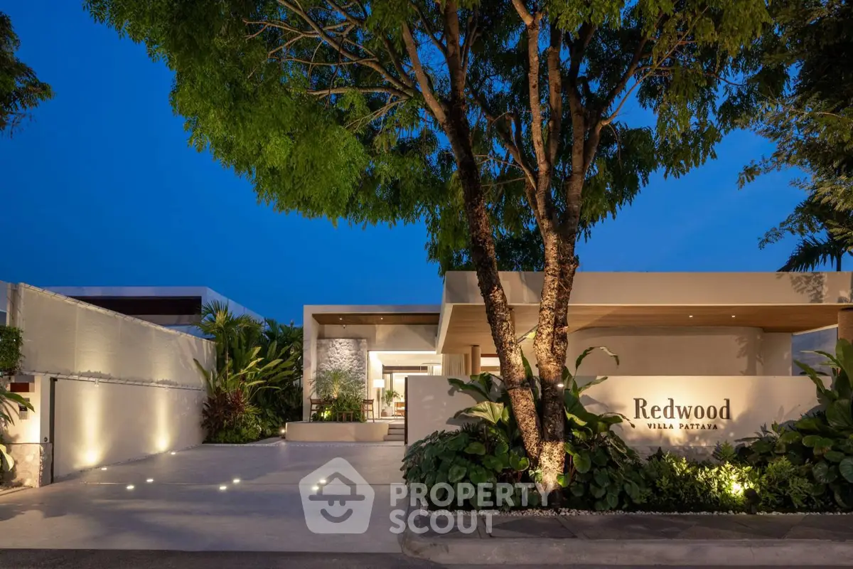 Luxurious modern villa entrance with ambient lighting and lush greenery at Redwood Villa Pattaya.