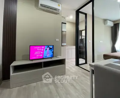 Modern living room with sleek design, featuring a TV, air conditioning, and stylish furniture in a cozy apartment.
