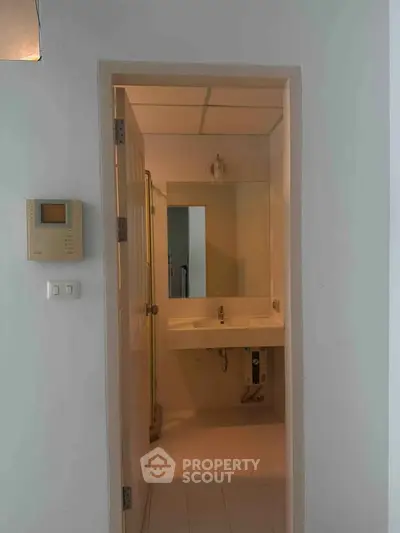Modern bathroom with sleek sink and minimalist design, featuring a wall-mounted control panel.