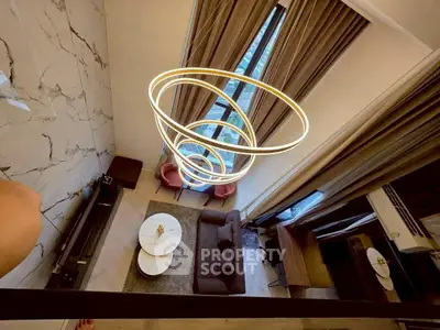 Luxurious modern living room with high ceilings and elegant lighting in a stylish apartment.