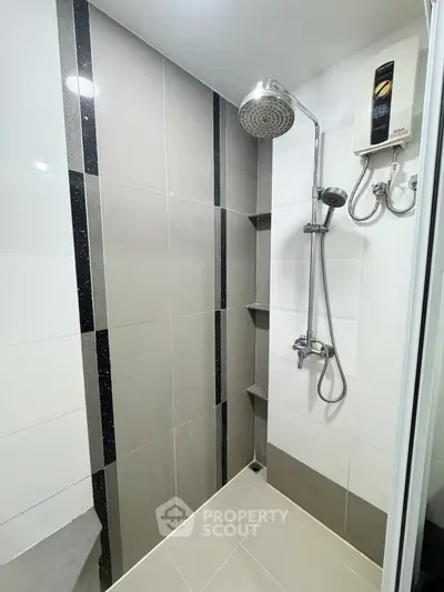 Modern bathroom with sleek shower design and water heater, featuring elegant tile work.
