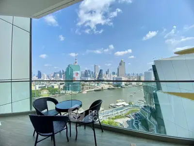 Stunning cityscape view from a modern balcony with seating area overlooking a river.