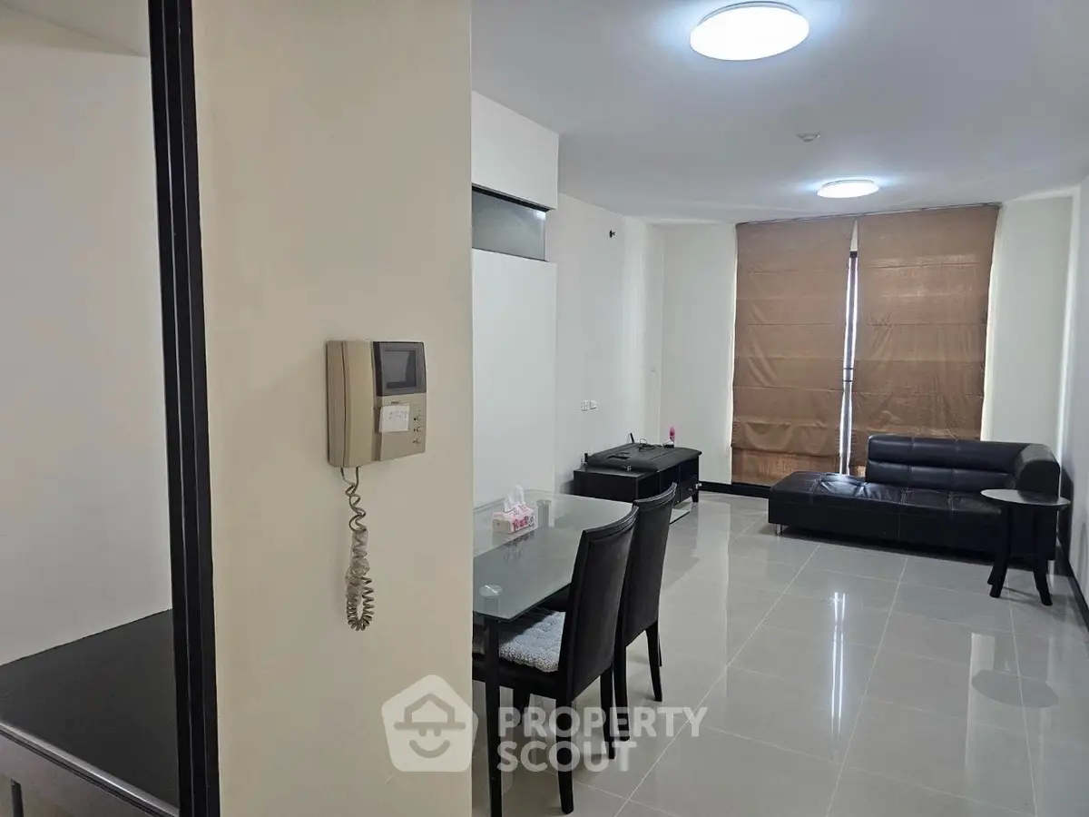 Modern living room with sleek furniture and dining area, featuring neutral tones and ample natural light.