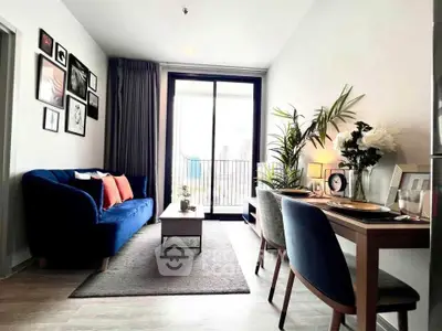 Modern living room with stylish decor and large window offering city views.
