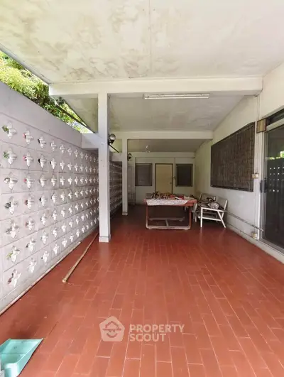 Spacious covered patio with brick flooring and decorative wall blocks