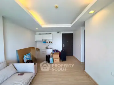Spacious living room with modern open kitchen and cozy seating area, perfect for urban living.