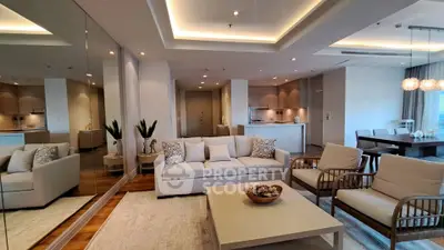 Luxurious open-plan living room with elegant furniture and modern kitchen in upscale apartment.