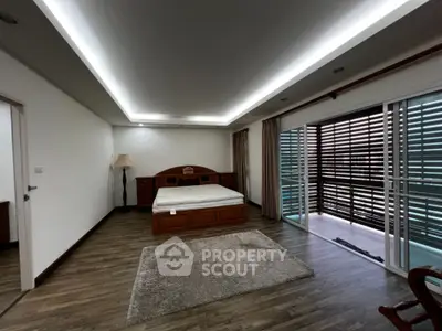 Spacious and elegantly designed bedroom with modern lighting, large windows, and premium wooden flooring, offering a serene and luxurious living experience.