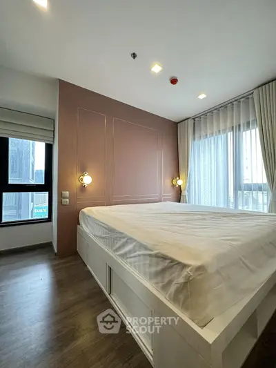 Modern bedroom with large windows and elegant lighting in a high-rise apartment.