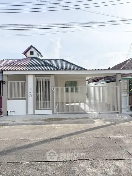 Charming single-story home with gated entrance and tiled roof in a quiet neighborhood.