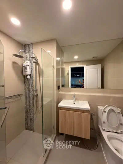Modern bathroom with glass shower and sleek fixtures in a contemporary apartment.