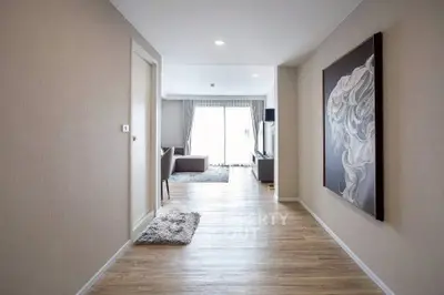 Spacious modern hallway leading to a bright living room with elegant decor.