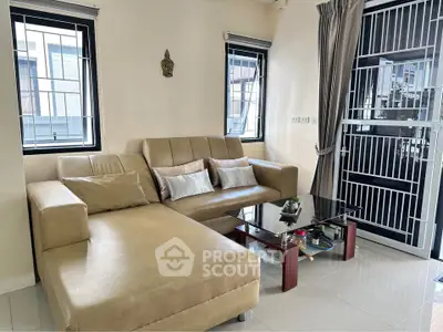 Stylish living room with modern leather sofa and glass coffee table in bright interior.