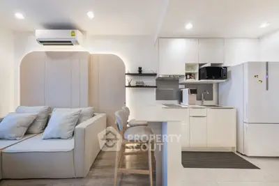 Modern open-layout kitchen and living area with sleek design and neutral tones.