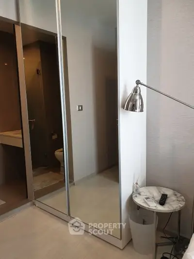 Modern bathroom with sleek mirror and stylish lamp in contemporary apartment.