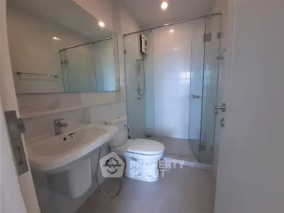 Modern bathroom with glass shower enclosure and sleek fixtures